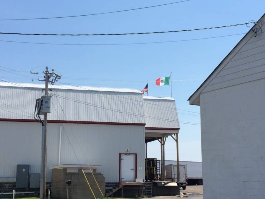 American and Mexican flags displayed in front of a commercial crab processing plant.
